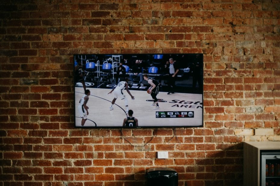 Ein Fernsehr hängt an einer Wand und zeigt ein Sport Programm
